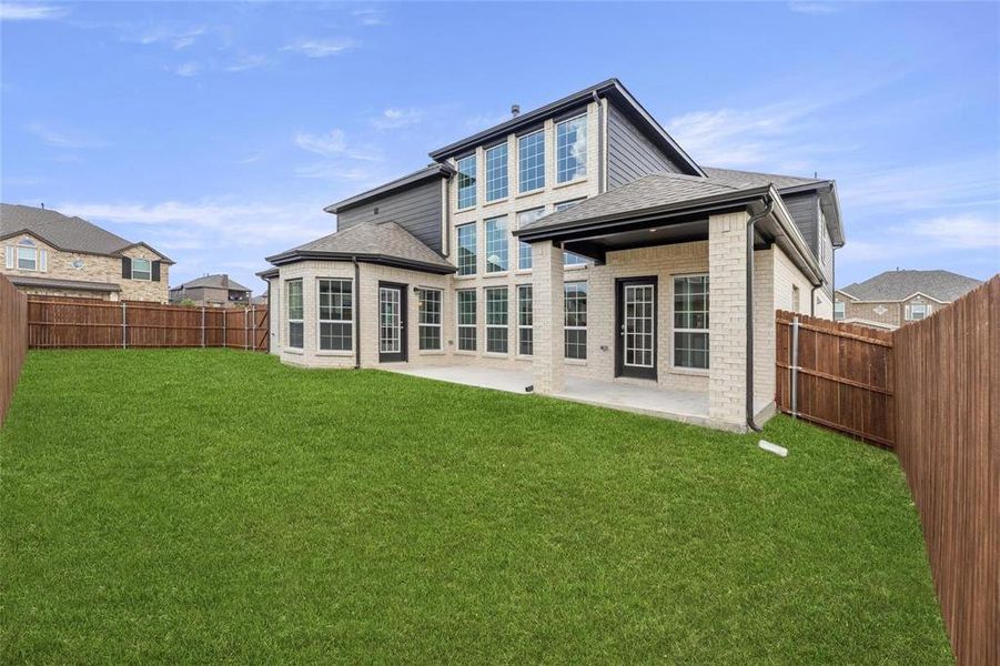 Back of house with a patio and a yard