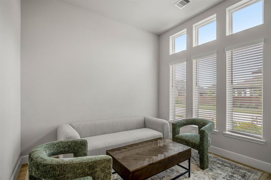 Nestled away quietly in the front of the home is the home office space. Featuring large windows letting in bright natural light, wood like flooring, neutral paint, and high ceilings.