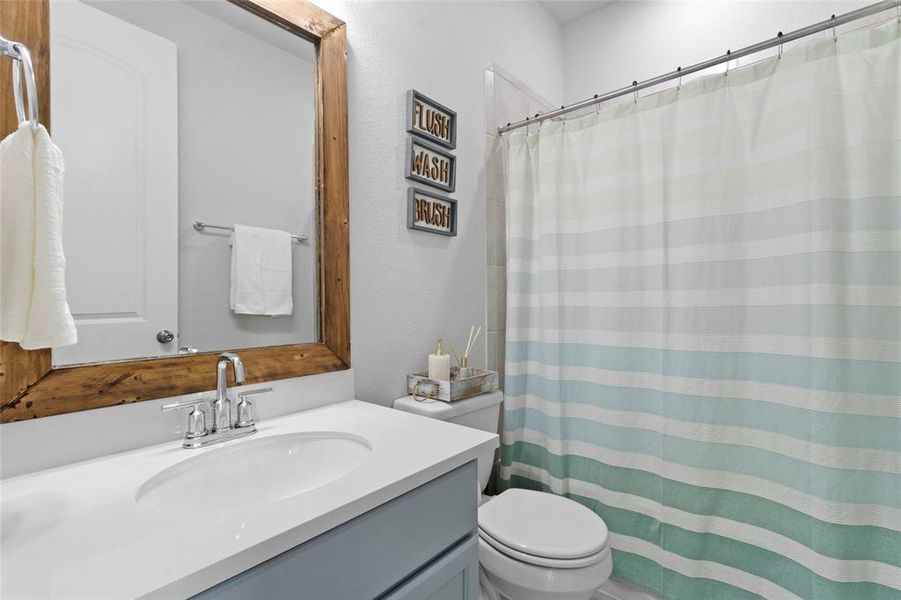 Convenient downstairs full guest bathroom with modern finishes, perfect for visitors or complementing a secondary suite.