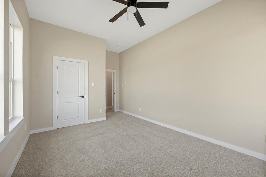 Empty room featuring light carpet and ceiling fan