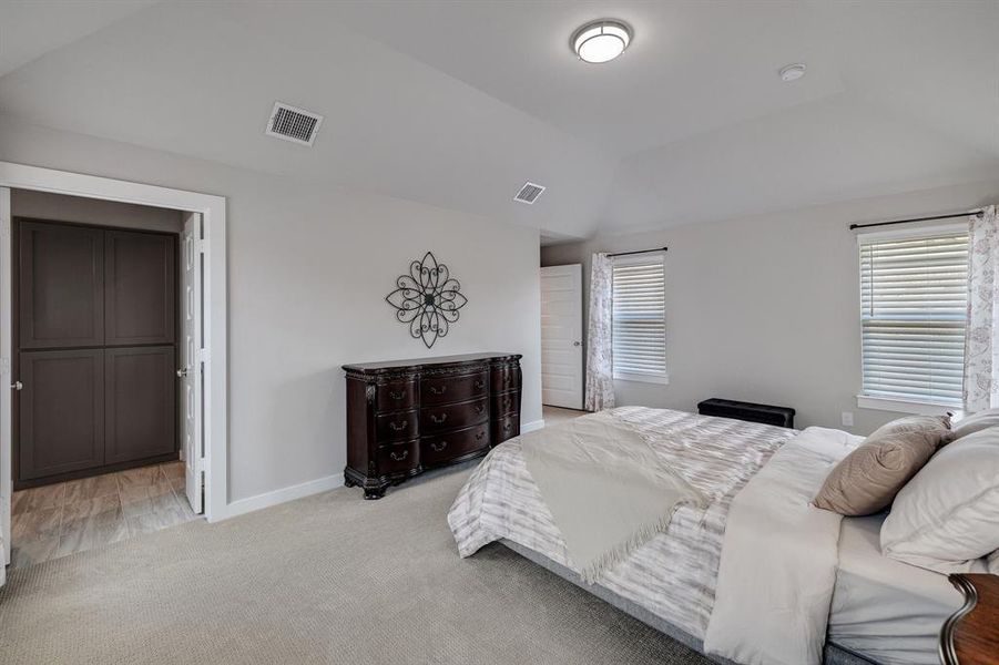 Bedroom featuring vaulted ceiling and light colored carpet