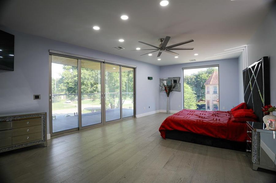 Bedroom featuring hardwood / wood-style floors, ceiling fan, and access to exterior