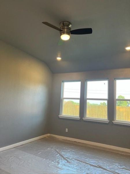 Spare room featuring ceiling fan and vaulted ceiling