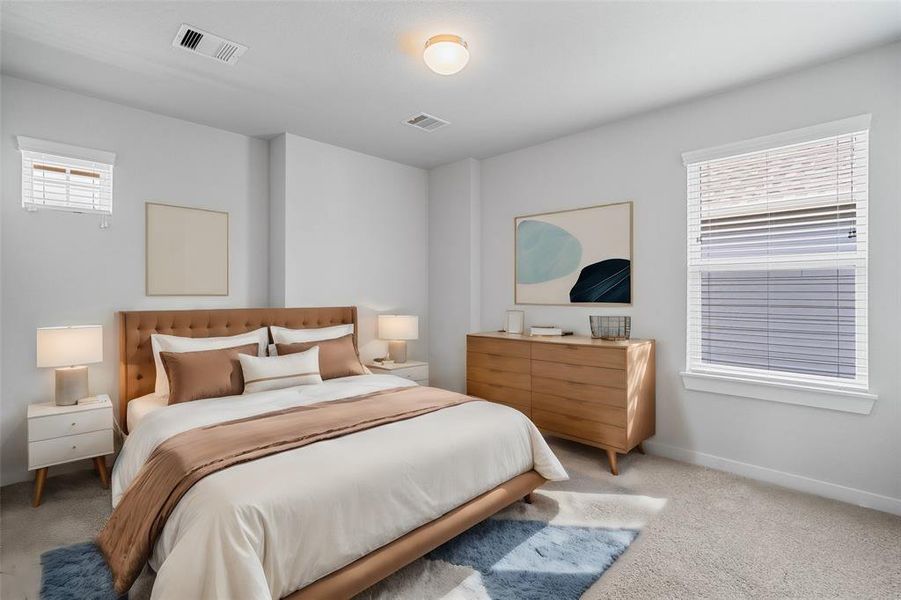 This secondary bedroom features high ceilings, custom paint, plush carpet, and a large window with privacy blinds!