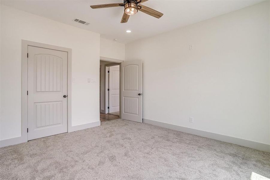 Unfurnished bedroom featuring light colored carpet and ceiling fan