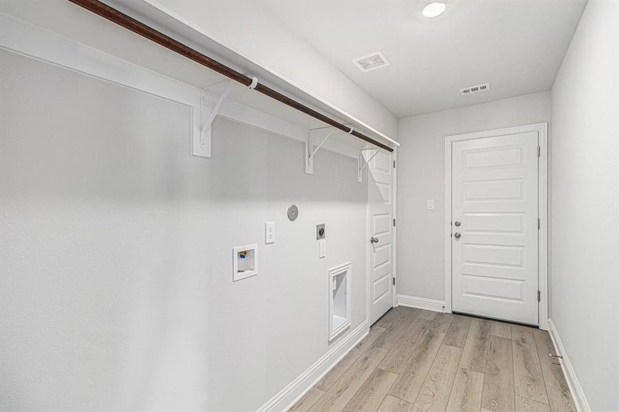 Generous Utility Room with Access to Primary Walk-in Closet