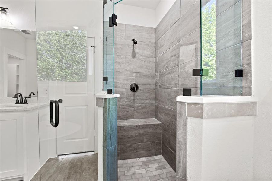 Bathroom featuring a shower with door, vanity, and hardwood / wood-style floors