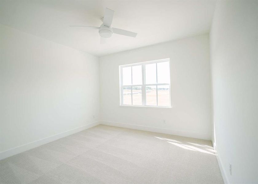 Empty room featuring ceiling fan and light colored carpet