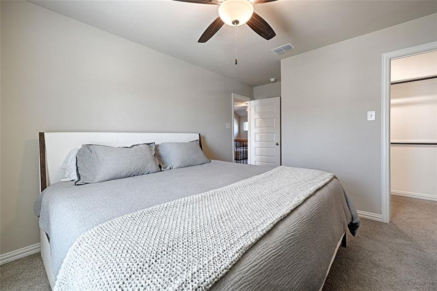 Bedroom 2 upstairs with fan, plush carpet and walk-in-closet