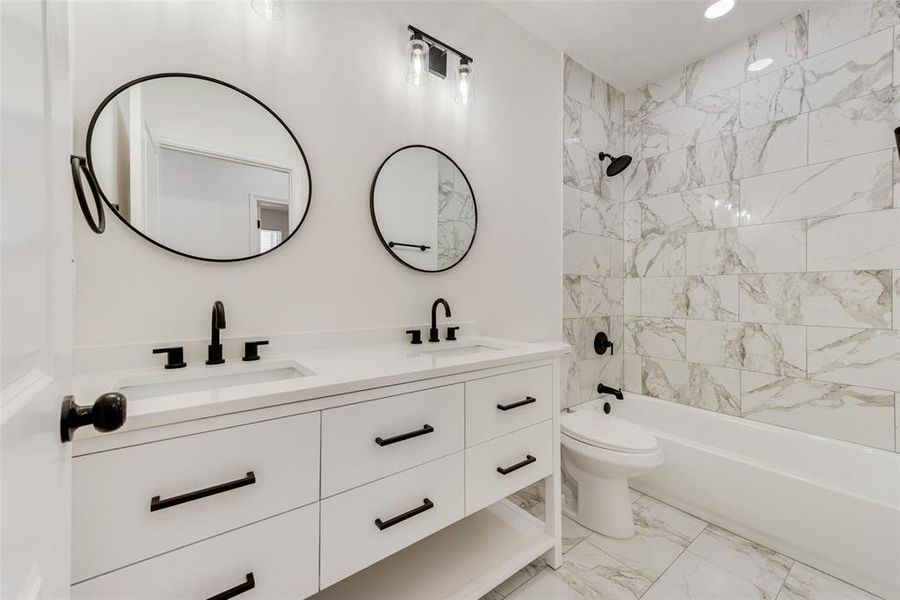 Full bathroom with tiled shower / bath, vanity, and toilet