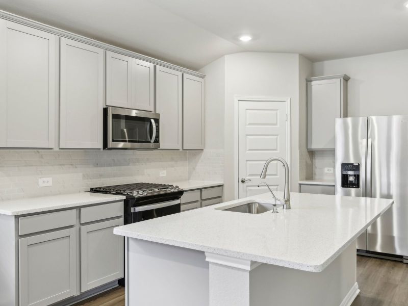 The kitchen features grey stone-colored cabinets and quartz countertops.