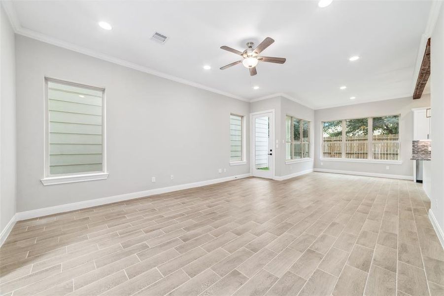 Experience the elegance of ceramic tile flooring throughout the lower level, complemented by soaring vaulted ceilings. The living room is enhanced with a sleek ceiling fan, integrated with a modern light fixture.