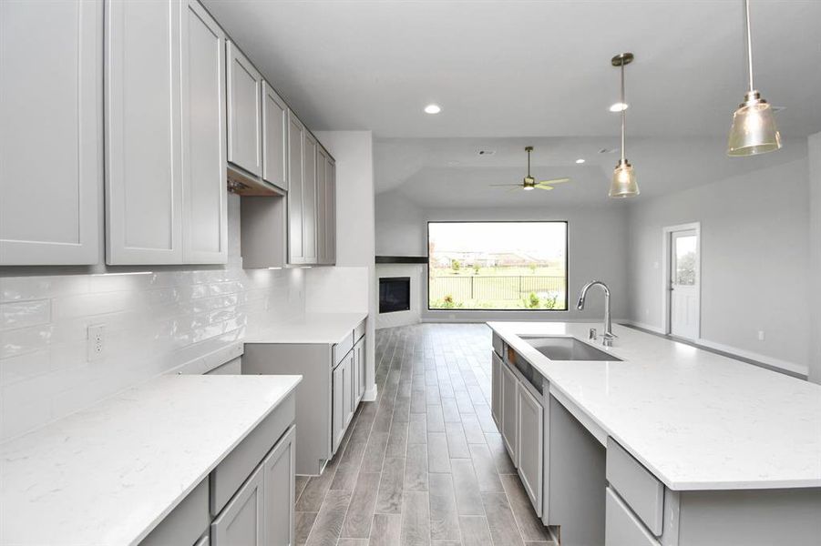 Culinary haven, featuring granite countertops, a tile backsplash, stainless steel appliances (to be installed), and 42” upper cabinets. Sample photo of completed home with similar floor plan. Actual colors and selections may vary.