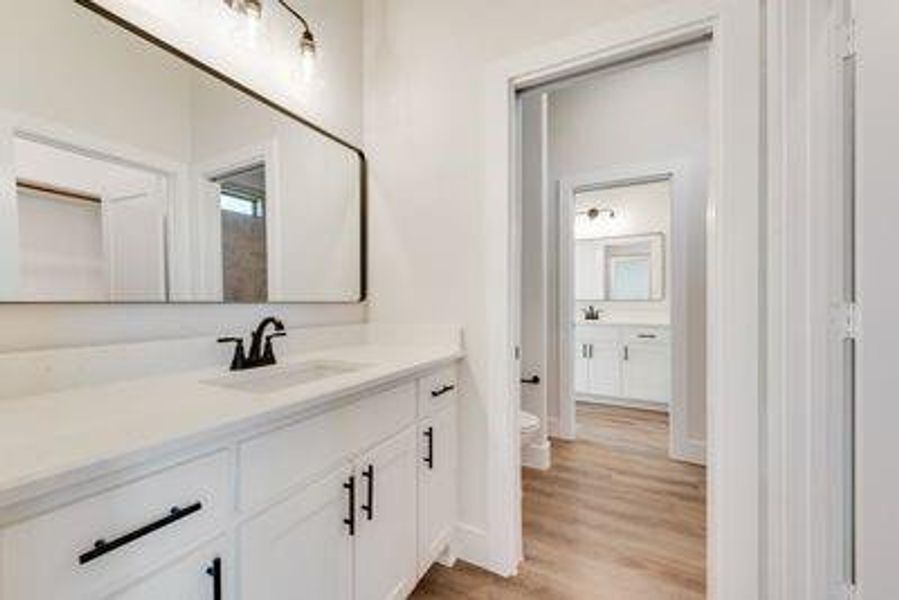 Bathroom with vanity, hardwood / wood-style floors, and toilet