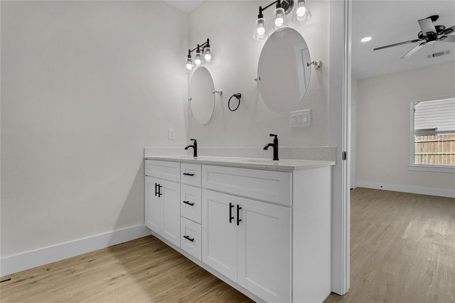 Bathroom with wood-type flooring, vanity, and ceiling fan