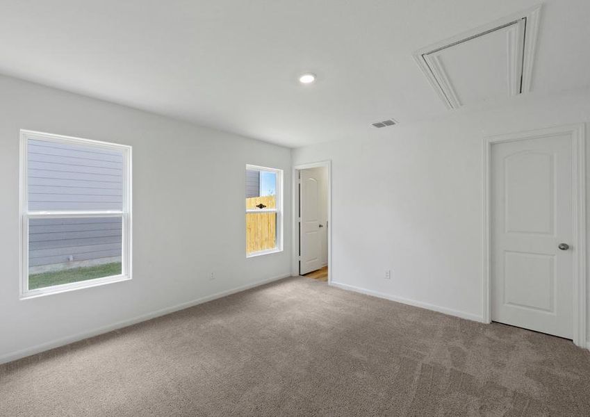 The master bedroom has two windows and lush carpet