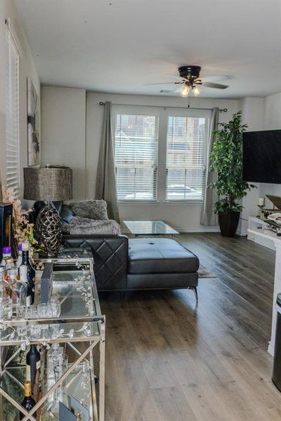 Living room with wood-type flooring and ceiling fan