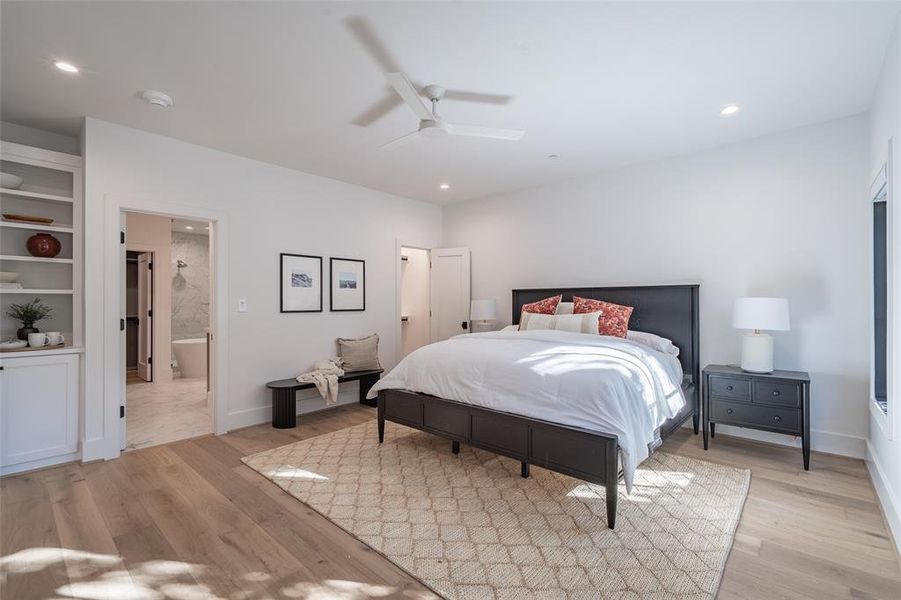 Bedroom with connected bathroom, light hardwood / wood-style floors, and ceiling fan