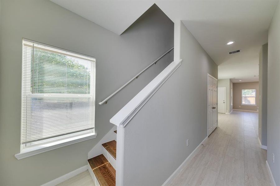 The elegant stairwell serves as a stunning transition to the second floor, enhancing the flow of the home. Its design adds a touch of sophistication while guiding you seamlessly between levels. This inviting space not only showcases beautiful craftsmanship but also connects the various areas of the house, reinforcing the home's open and cohesive feel.