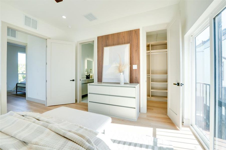 Bedroom with light hardwood / wood-style flooring, a walk in closet, and a closet