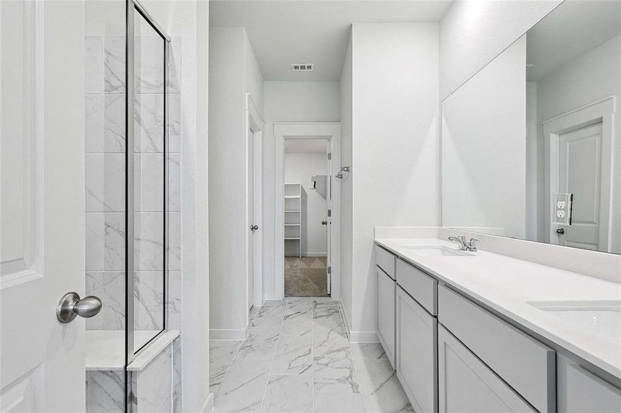 Bathroom featuring tile patterned flooring, vanity, and walk in shower