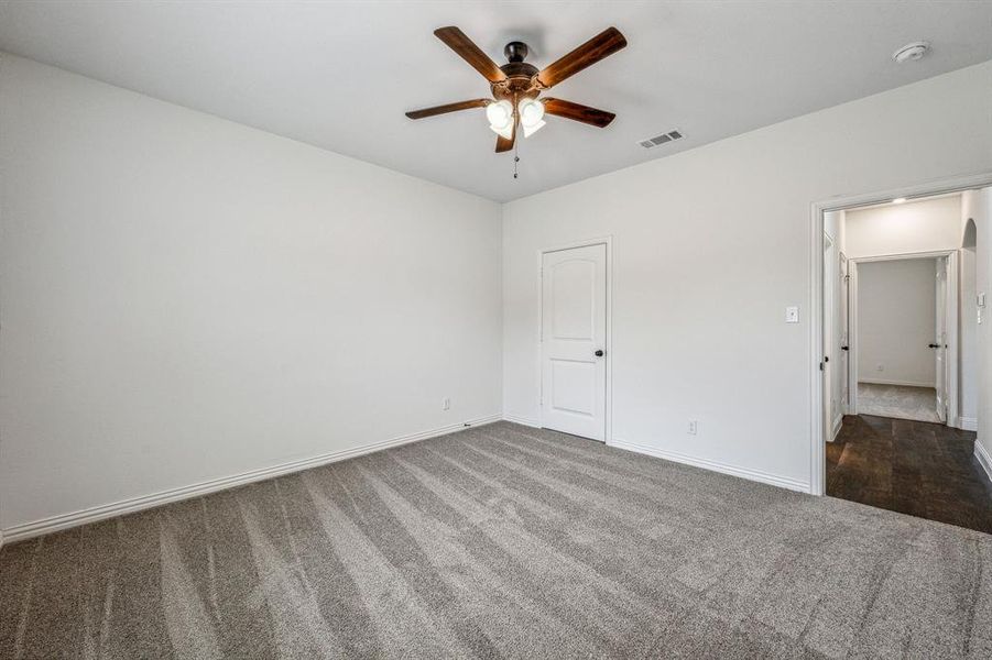 Unfurnished bedroom with ceiling fan and carpet flooring