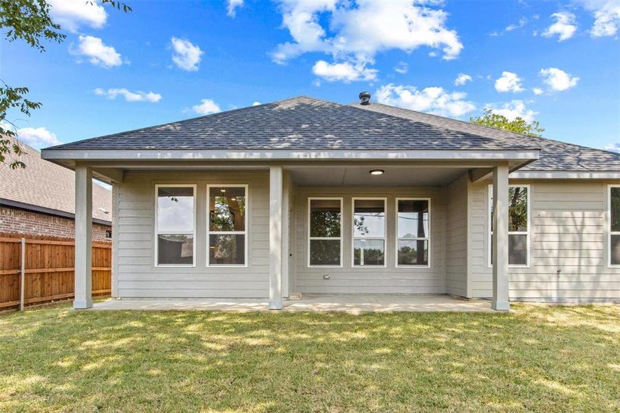 Back of property featuring a patio area and a lawn