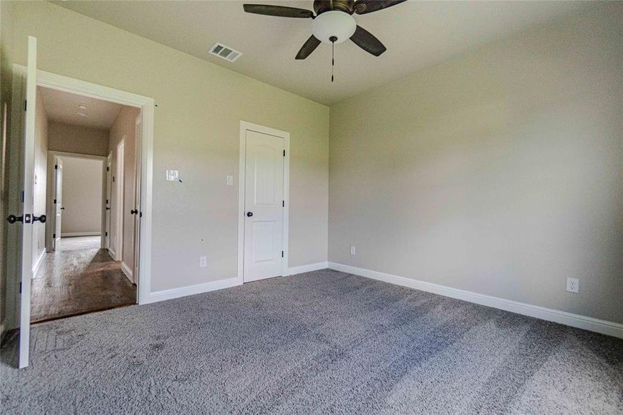 Unfurnished bedroom with carpet flooring and ceiling fan