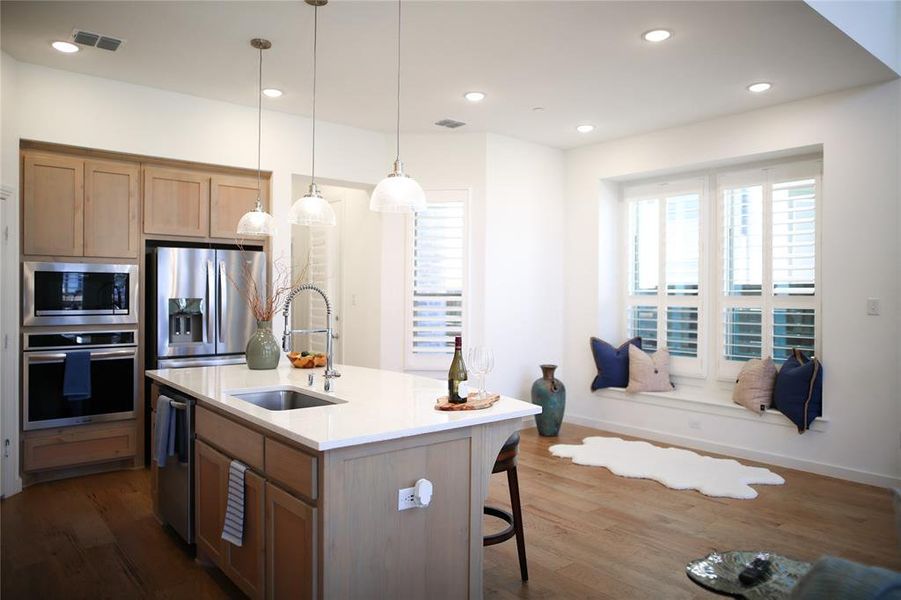 Kitchen with appliances with stainless steel finishes, dark wood-type flooring, an island with sink, and sink