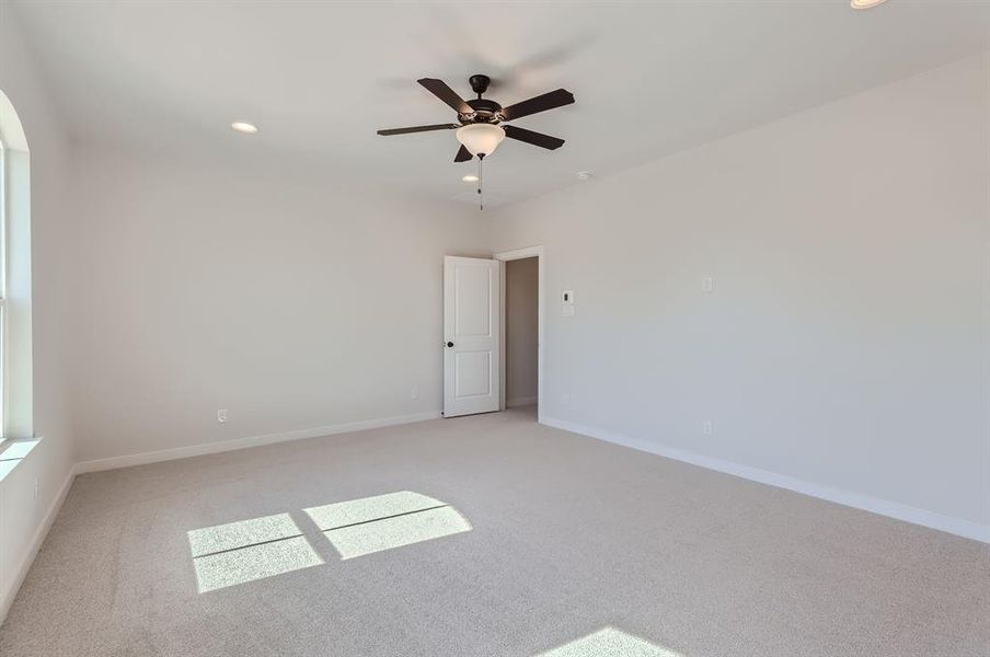 Unfurnished room featuring light carpet and ceiling fan