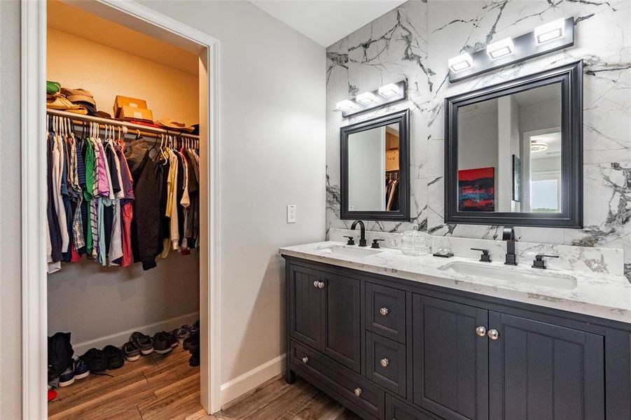 Owners suite equipped with large walk in closet just off of the dressing area with double vanities and led lighting