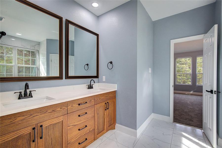 Master bathroom with dual bowl vanity and tile patterned floors