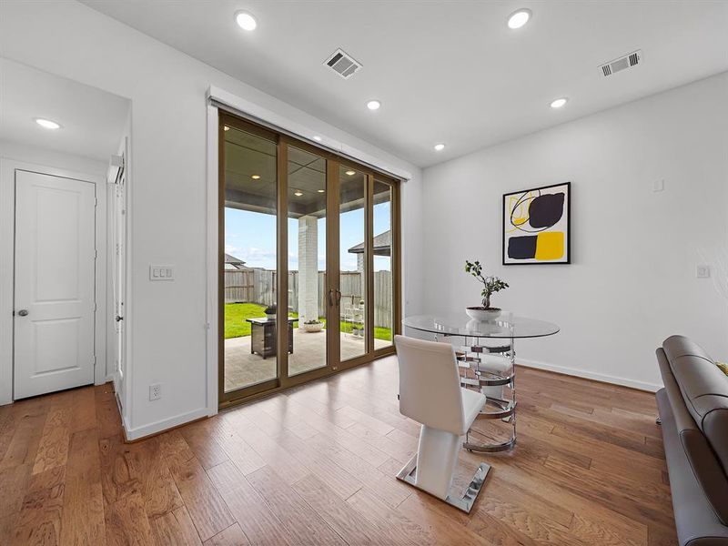 This expansive dining area boasts enormous sliding glass doors that seamlessly connect the indoors to the outdoors, inviting an abundance of natural light to flood the room. Step through to the covered patio, where you can enjoy alfresco dining or simply relax in a serene setting.