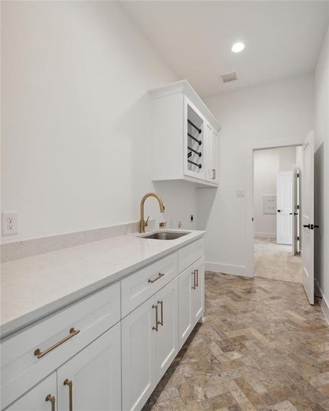 Kitchen featuring white cabinets and sink