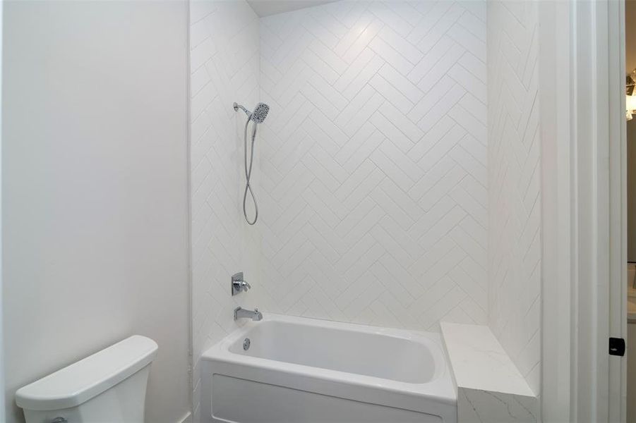 Bathroom with toilet and tiled shower / bath