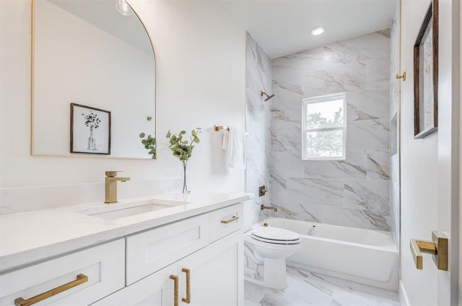 Full bathroom featuring tiled shower / bath, tile flooring, toilet, and vanity