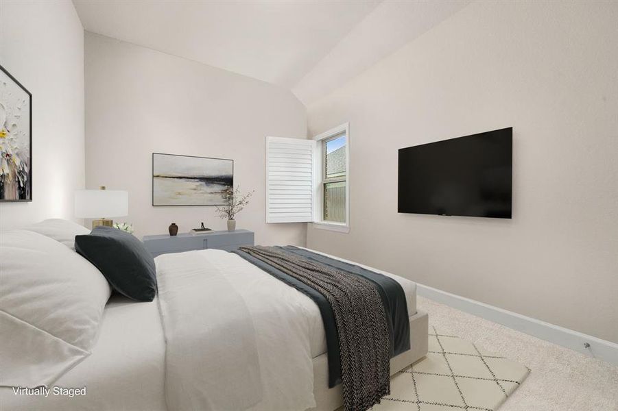 Secondary bedroom features plush carpet, neutral paint, dark stained ceiling fan with lighting and a large window with plantation shutters.