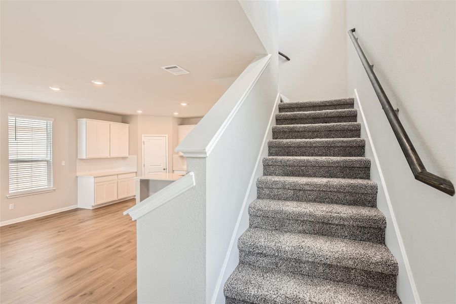 Cozy carpeting runs up the stairs and throughout the second floor bedrooms and hallway.