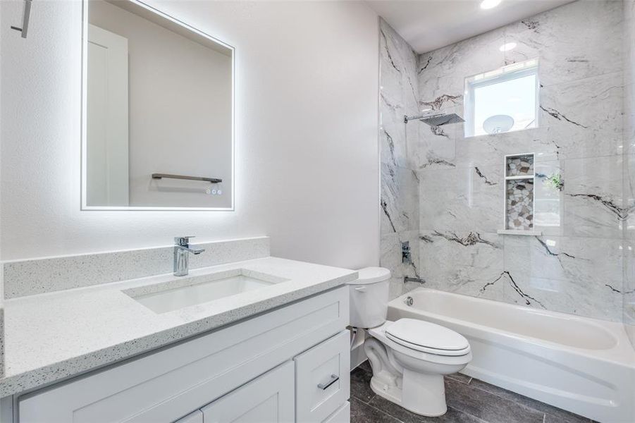 Full bathroom with tiled shower / bath, tile flooring, toilet, and vanity