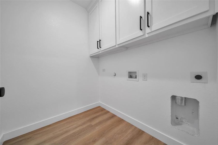 Laundry area featuring cabinets, hookup for a washing machine, electric dryer hookup, light hardwood / wood-style flooring, and hookup for a gas dryer