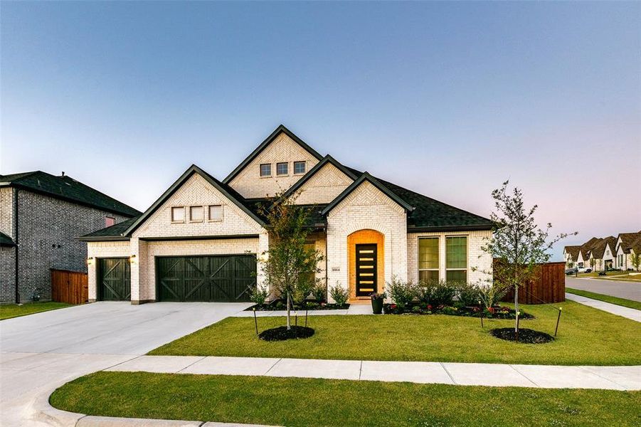 View of front of house featuring a garage and a lawn