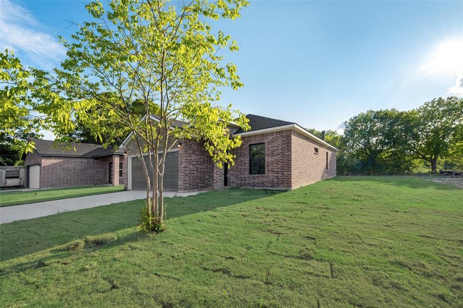 View of front of home featuring a garage and a front yard