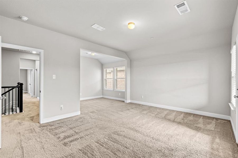 Carpeted spare room with lofted ceiling