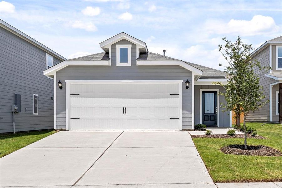 Front of house featuring a front yard and a garage