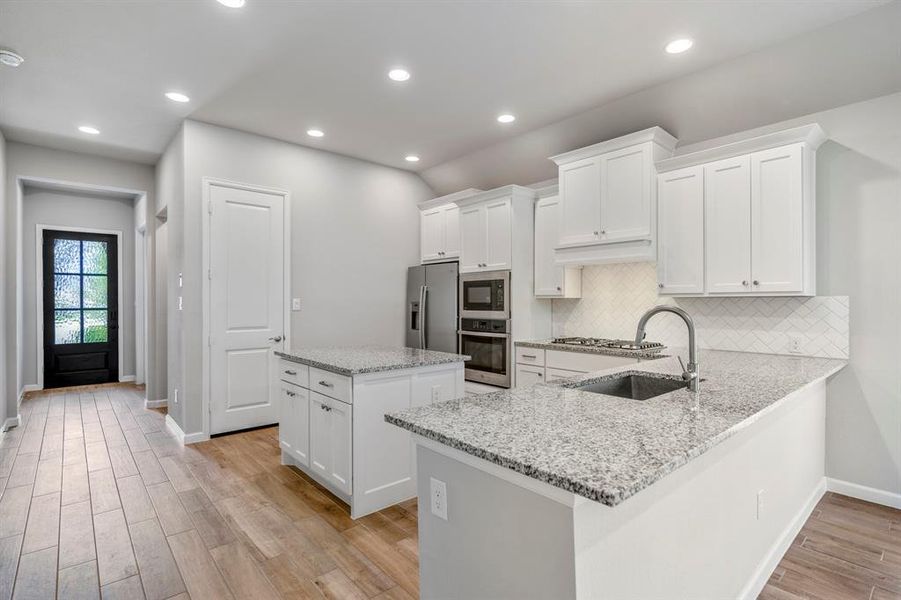 Island and a breakfast bar to maximize the spacious feel