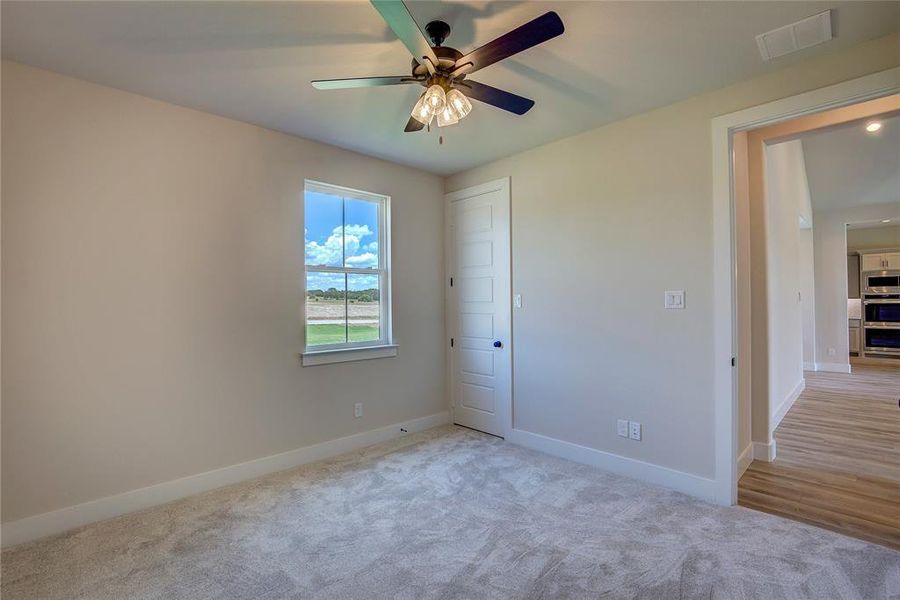 Unfurnished bedroom featuring ceiling fan and hardwood / wood-style floors