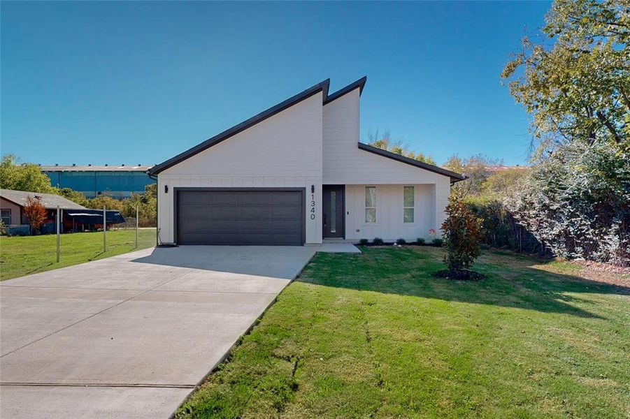 View of front of house featuring a garage and a front lawn