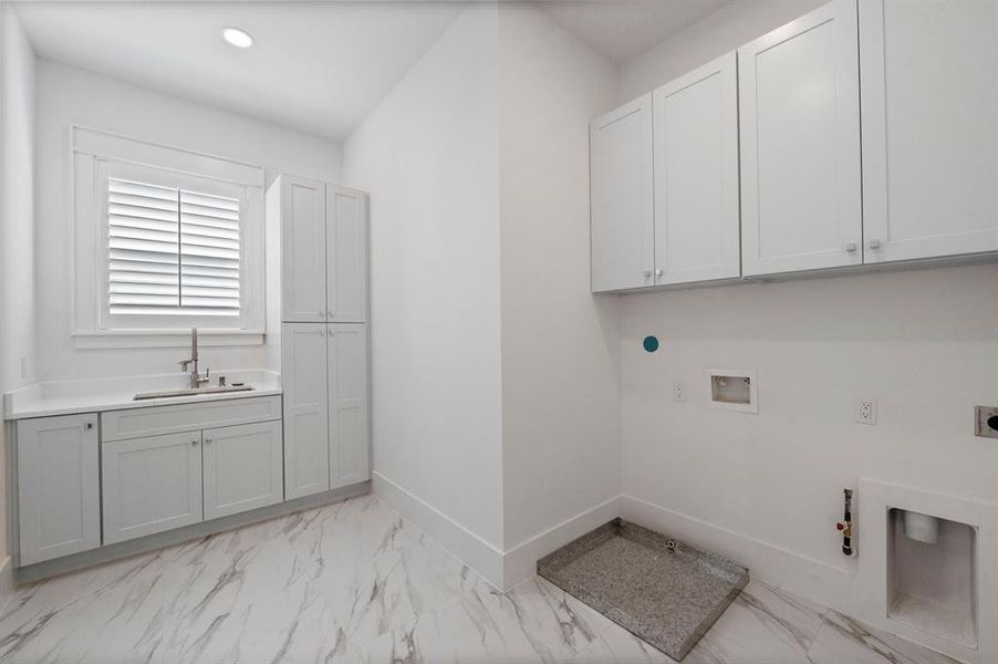 This laundry room is every persons dream with a sink, folding area and tons of additional storage for all of your wash and cleaning supplies.