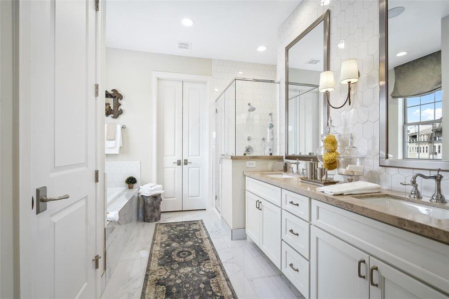 Equipped with double sinks, glass-door shower, and built-in soaking tub, the Primary Bathroom offers complete relaxation while remaining highly functional. Photo is of an existing home & used for representative purposes only.