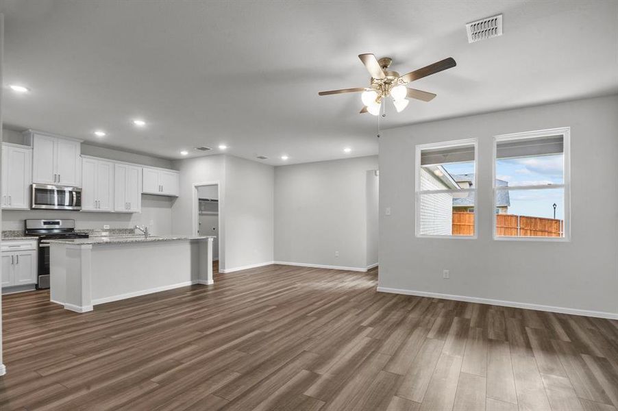 Kitchen featuring white cabinetry, a kitchen island with sink, dark hardwood / wood-style floors, and stainless steel appliances